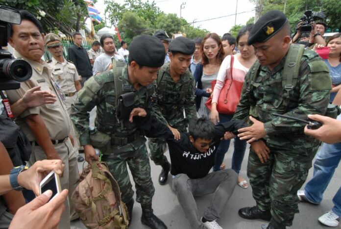 Soldiers break up a small rally by activists seeking to show solidarity with the seven jailed referendum campaigners last July in front of the Bangkok Remand Prison.