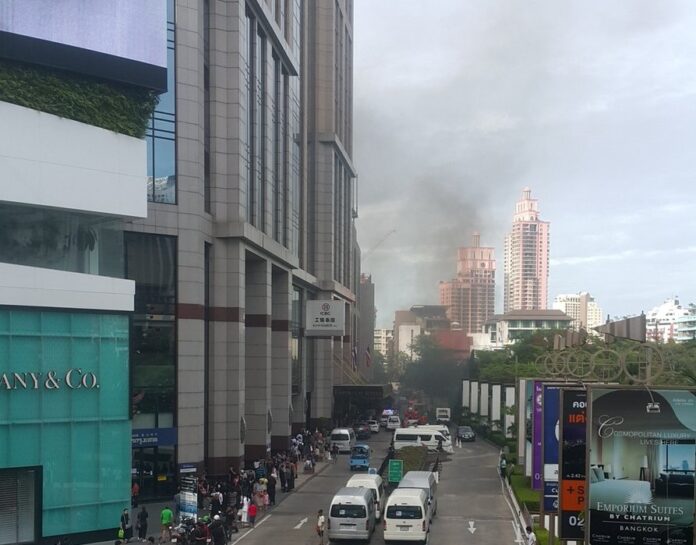 Smoke is seen outside the Emporium shopping mall Thursday morning. Photo: @nidneung123 / Twitter