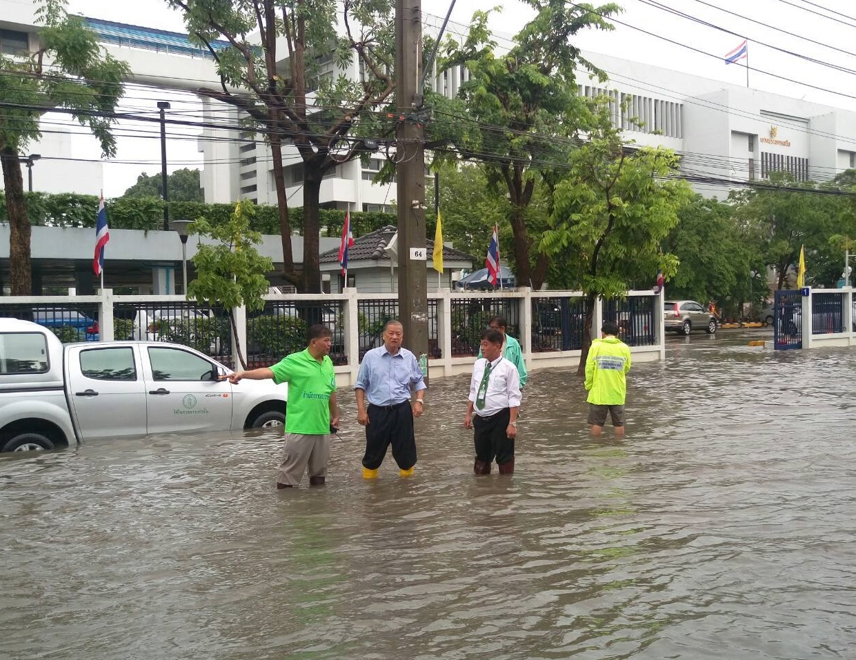 Bangkok Gov. Sukhumbhand Paribatra surveys the water drainage system Tuesday morning in front of the Criminal Court on Ratchadaphisek Road in Bangkok.