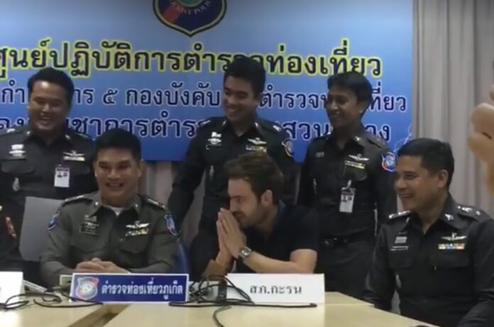 Jack Brown offers a wai offscreen to a taxi driver Monday at the Phuket Tourist Police station. Photo: Phuket Times Newspaper / Facebook
