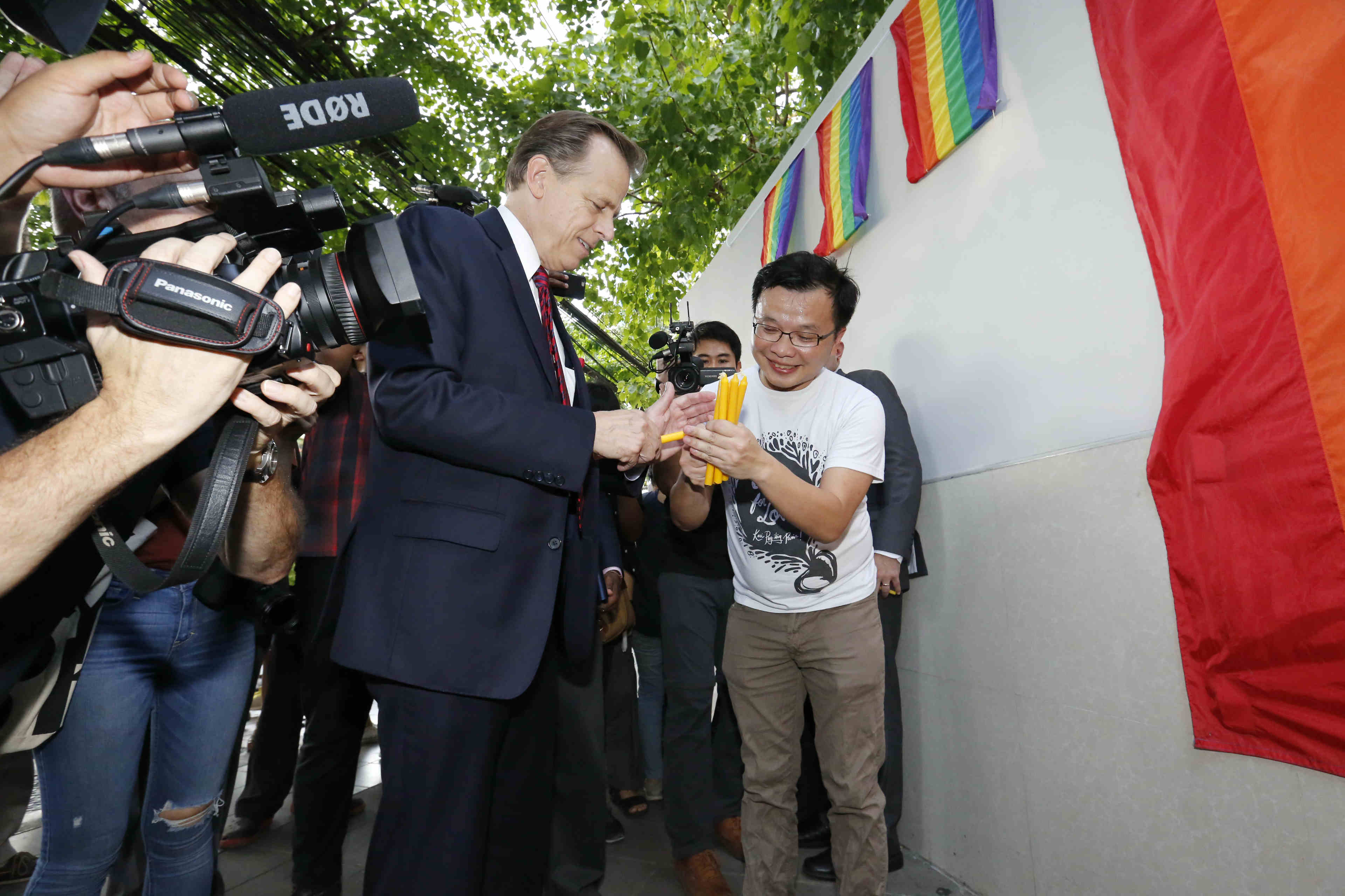 U.S. Ambassador Glyn Davies lights a candle Monday evening outside the U.S. Embassy in Bangkok.