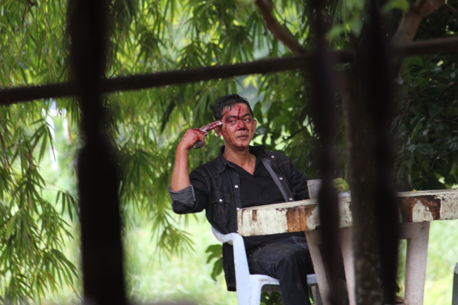 Gun to temple, Piya Sukijkanond threatens suicide Tuesday after shooting six of his family members, one fatally, in the Phun Phin district of Surat Thani province.