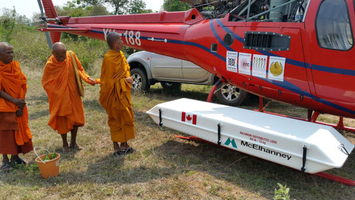 Buddhist monks bless a helicopter and the lidar instrument within its pod at the remote temple complex of Banteay Chhmar in Cambodia in an undated photo. Photo: Damian Evans / French Institute of Asian Studies in Paris / Associated Press