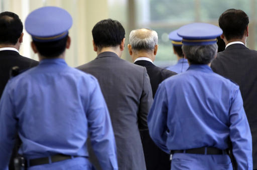 In this Tuesday, June 14, 2016 photo, Tokyo governor Yoichi Masuzoe, fourth from left, surrounded by security personnel, walks on the hallway at Tokyo Metropolitan Government headquarters in Tokyo. Photo: Eugene Hoshiko / Associated Press