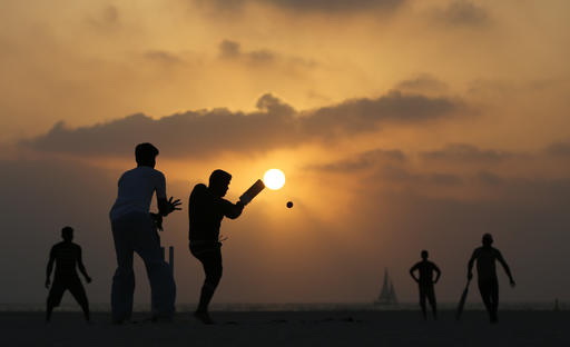 While the sun sets, Asian fishermen of the newly developed Jumeirah Fishing Harbour at the Umm Suqeim district, play cricket by the Gulf waters in Dubai, United Arab Emirates, Tuesday June 14, 2016. Photo: Kamran Jebreili / Associated Press