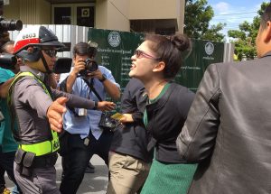 Police drag Jemjuree Chuayprad away on Tuesday morning after she shouted her complaint at Prime Minister Prayuth Chan-ocha at Government House.