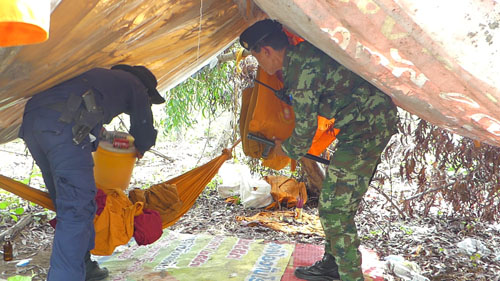 Police search through the belongings of a group of Cambodian monks Saturday in northern metro Bangkok.