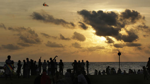 In this April 13, 2010, file photo, people fly kites as others watch the sunset on the last day of the Sinhala year, in Colombo, Sri Lanka. Photo: Manish Swarup / Associated Press
