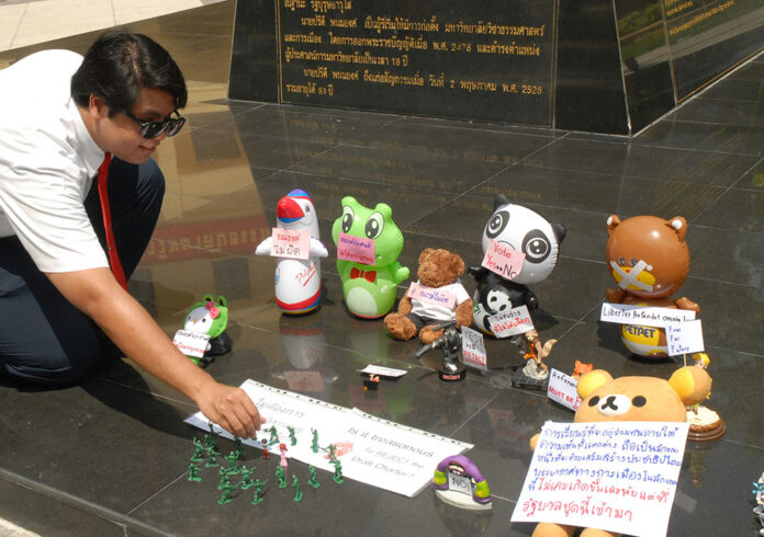 Activist Kittipthet Sumalnop arranges toys Wednesday at Thammasat University's Tha Prachan campus.