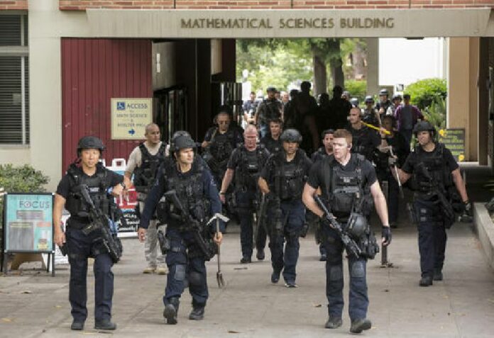 LAPD officers walk by the Mathematical Sciences Building on the UCLA campus Wednesday after a fatal shooting there. Photo: Damian Dovarganes / Associated Press