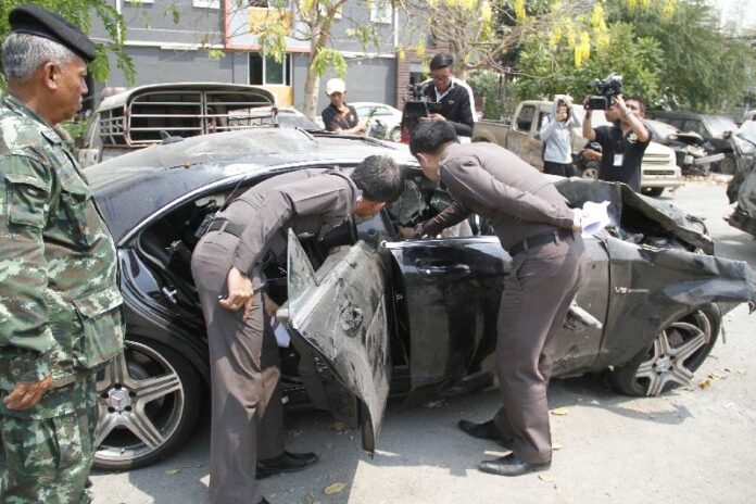 Officers at Phra-Inracha Police Station inspect a Mercedes-Benz on March 17 four days after it was involved in a fatal highway crash.