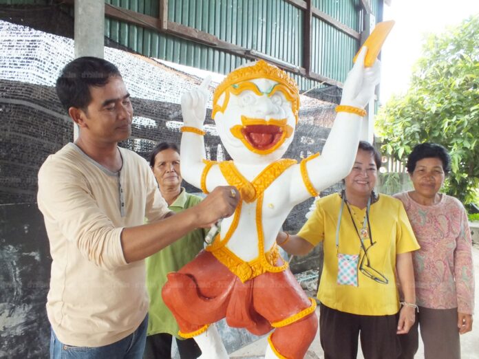 A Korat artist poses for photo on July 11, 2016, with candlewax crafted into the figure of Hanuman, the monkey god adopted by the Election Commission as its mascot for the August 2017 charter referendum.