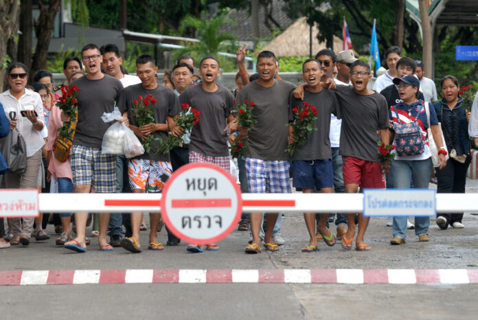 The six activists, in grey shirts, walk out of Bangkok Remand Prison on Wednesday morning. Their friend Korakot Saengyenpan was prevented from leaving with them at the last minute.