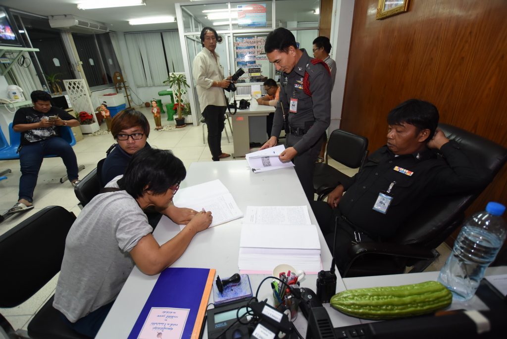 Sirikan Sirisitthidamrongkit signs a paper to withdraw charge against her son. 