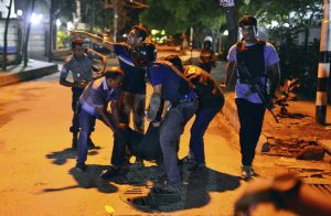 People help an unidentified injured person after a group of gunmen attacked a restaurant popular with foreigners in a diplomatic zone of the Bangladeshi capital of Dhaka on Friday. Photo: Associated Press