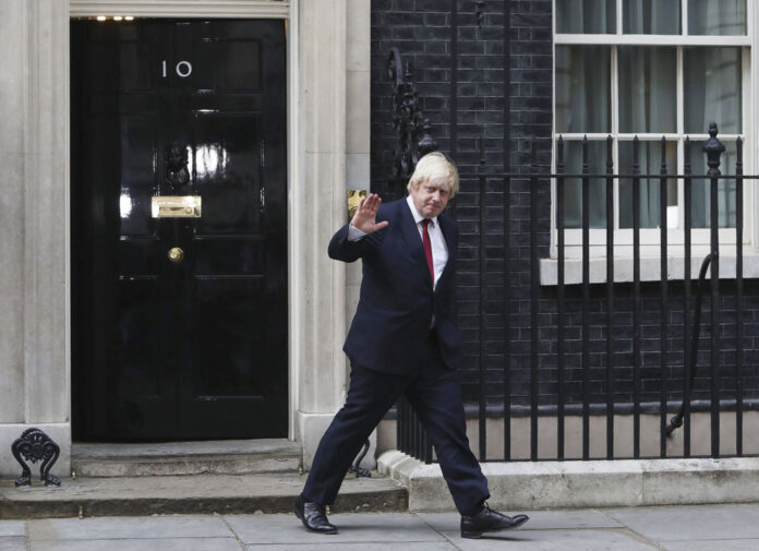 Boris Johnson leaves 10 Downing Street after being appointed Foreign Secretary Wednesday. Photo: Steve Parsons / PA / Associated Press