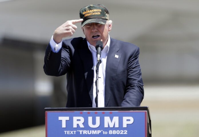 In this June 3, 2016, photo, Republican presidential candidate Donald Trump gestures to a his camouflaged
