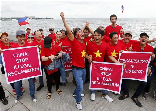 Vietnamese expatriates cheer while displaying placards during a rally by the Manila's baywalk before the Hague-based U.N. international arbitration tribunal is to announce its ruling on South China Sea Tuesday, July 12, 2016, Philippines. Photo: Bullit Marquez / Associated Press