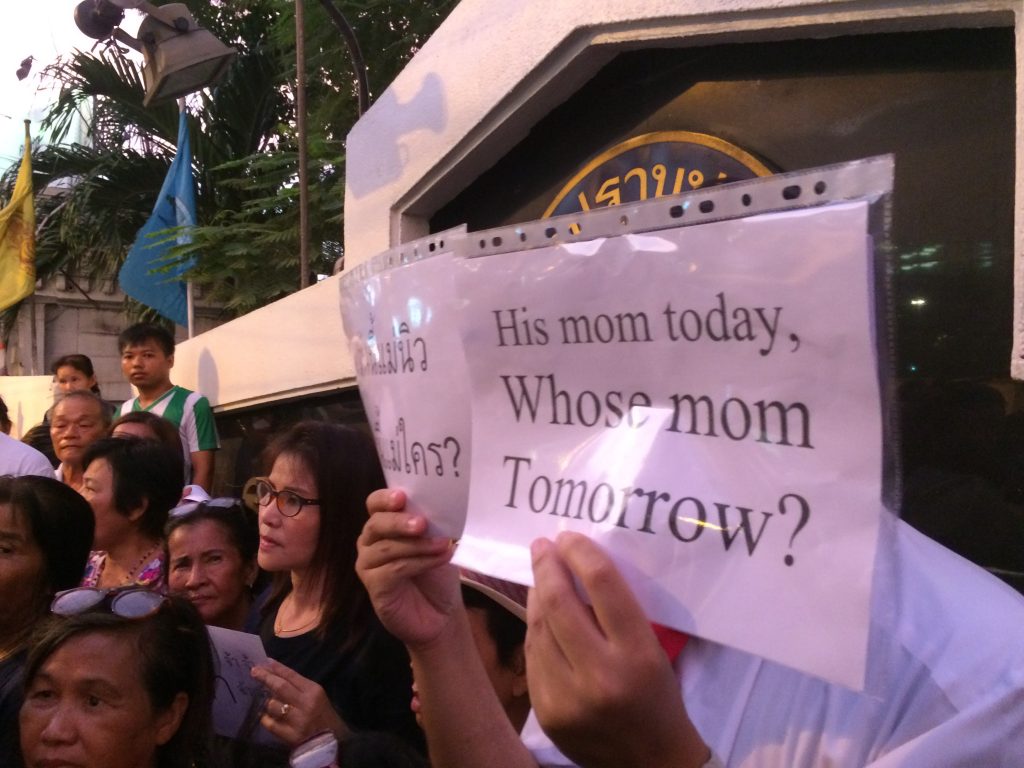A protestor holds a sign at the May 7 protest in front of Crime Suppression Division headquarters in Bangkok.