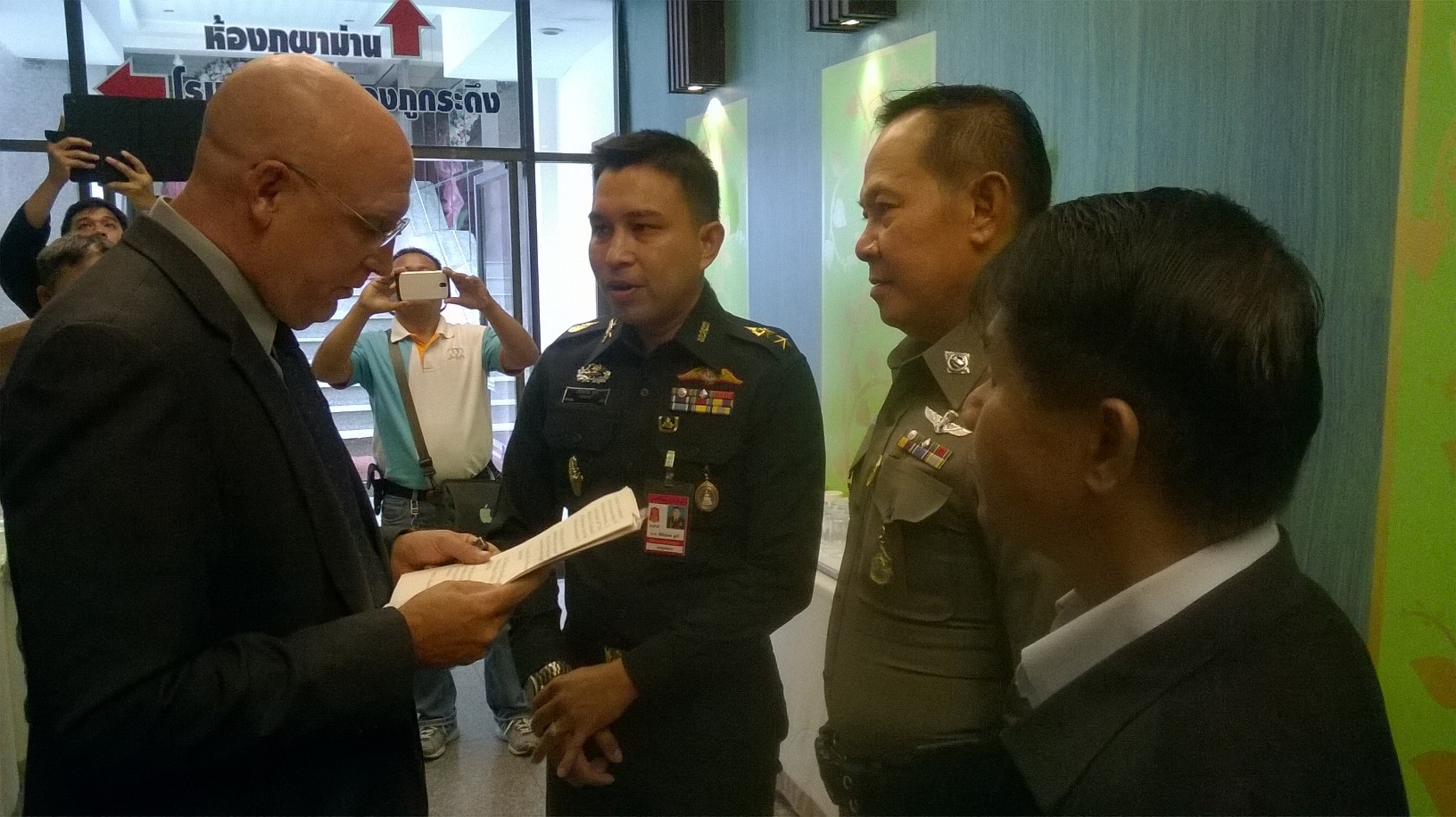 The Isaan Record editor David Streckfuss talks Friday to a soldier and police at the Khon Kaen Hotel. They warned him that anyone talking about politics or the lese majeste law shall be prosecuted. 