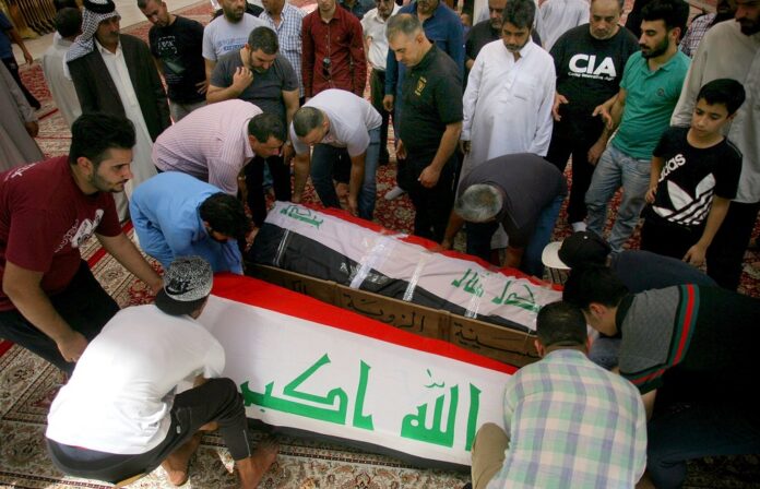Mourners carry the Iraqi flag-draped coffins of bomb victims, Talib Hassan, 35, and Hamza Jabbar, 37, during their funeral processions Sunday south of Baghdad. Photo: Anmar Khalil / Associated Press