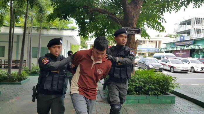 Chatree Ruamsungnoen, 27, is brought Monday to regional police headquarters in Bangkok where he confessed to killing a Saraburi province teacher.