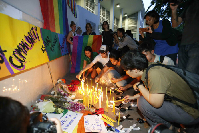 LGBT Activist Sulaiporn Chonwilai, front right, lights a candle at a June 13 vigil held at the U.S. Embassy in Bangkok for victims of the Orlando nightclub shooting.