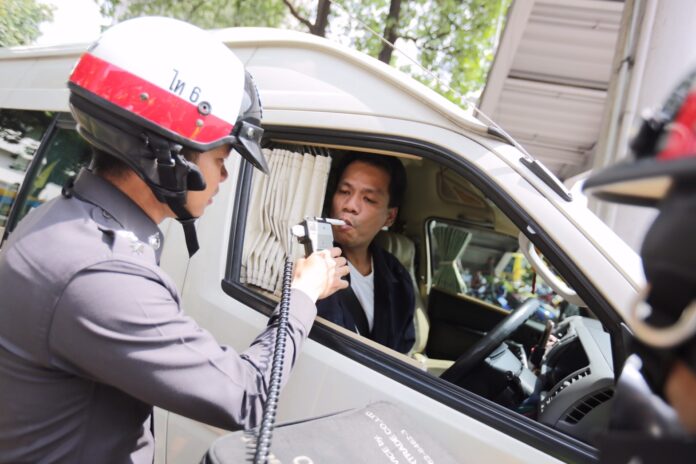 Police test a public van driver on July 15 for alcohol consumption in Bangkok