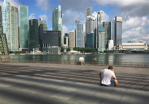 A man talks on his mobile phone in the Marina Bay financial district of Singapore on Tuesday, July 5, 2016. Photo: Wong Maye-E / Associated Press