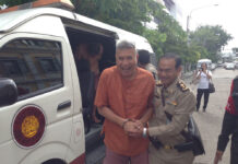 Singer ‘Tom Dundee’ Acquitted of Royal Defamation Thanat Thanawatcharanon, aka Tom Dundee, is led into the Bangkok Military Court on July 11.