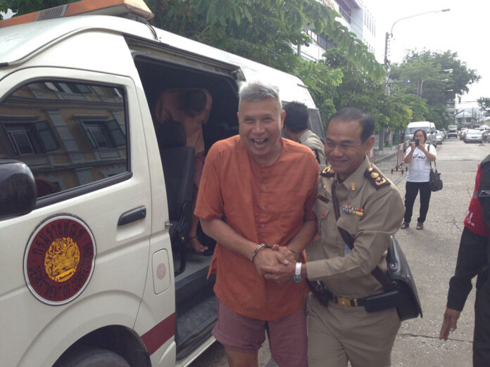 Thanat Thanawatcharanon, aka Tom Dundee, is led into the Bangkok Military Court on July 11. Thanat Thanawatcharanon, aka Tom Dundee, is led into the Bangkok Military Court on July 11.