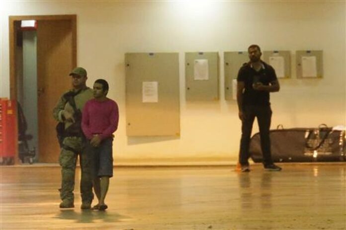 A federal police agent leads a handcuffed suspect who authorities say was arrested on terrorism-related charges in Brasilia, Brazil, Thursday, July 21, 2016. Photo: Associated Press