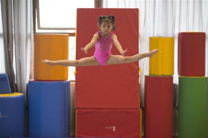In this photo taken Thursday, June 16, 2016, a young gymnast trains at the Xuhui Sports School in Shanghai, China. Photo: Associated Press