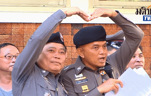 Police Lt. Gen. Sanit Mahathavorn demonstrates techniques for vocational students to make loving gestures when they run into one another instead of fighting in July