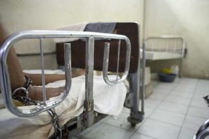 In this May 12, 2016 photo, one of four shackled prisoners rests in an empty emergency room, watched over by relatives and missionaries, but no medical personnel, at the Hospital of the State University of Haiti, in Port-au-Prince. Photo: Dieu Nalio Chery