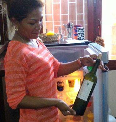 Kanokwan Saleephol, owner of Emmanuel Guesthouse, displays the bottle of wine consumed by the unidentified Frenchman who later turned up naked Friday in the road outside.