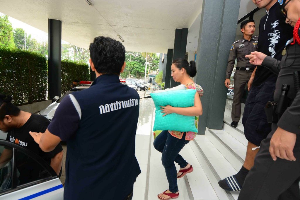 Clutching bedding for her imprisonment, Nattatika Worathaiwit is escorted by police on 29 April to the military court in Bangkok, where judges ordered her and another suspect, Harit Mahaton, to be remanded. 