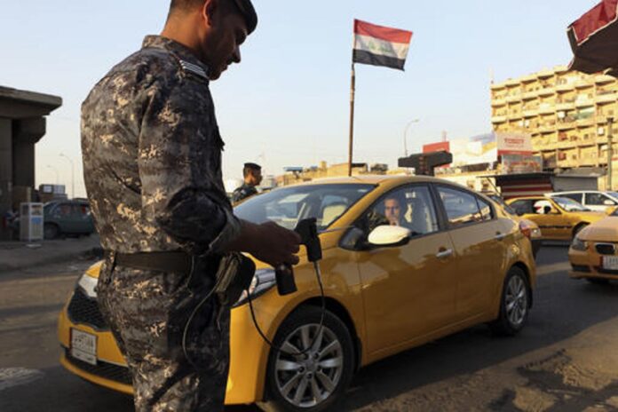 In this Thursday, July 14, 2016 picture, an Iraqi policeman uses a hand-held device that is supposed to detect bombs at a checkpoint in Basra, 340 miles (550 kilometers) southeast of Baghdad, Iraq. Photo: Nabil al-Jurani