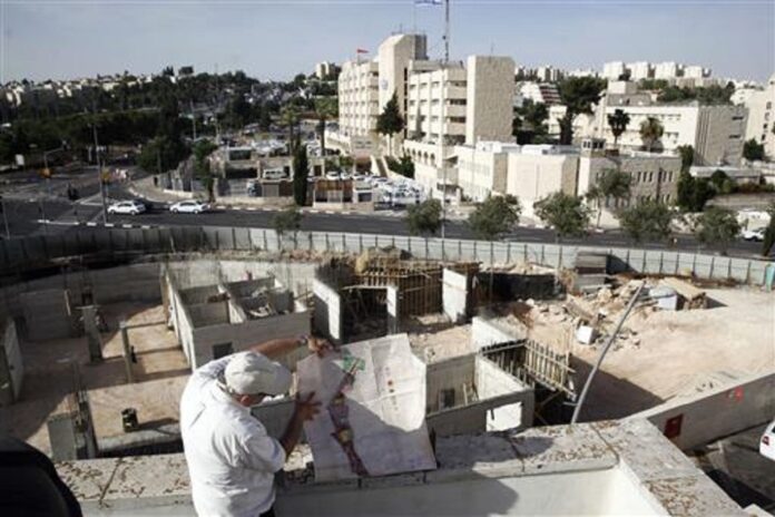 In this May 17, 2016 photo, Israeli lawyer Stephen Berman inspects a construction site on land owned by Palestinian Mohammad Abu Ta’a, in east Jerusalem.