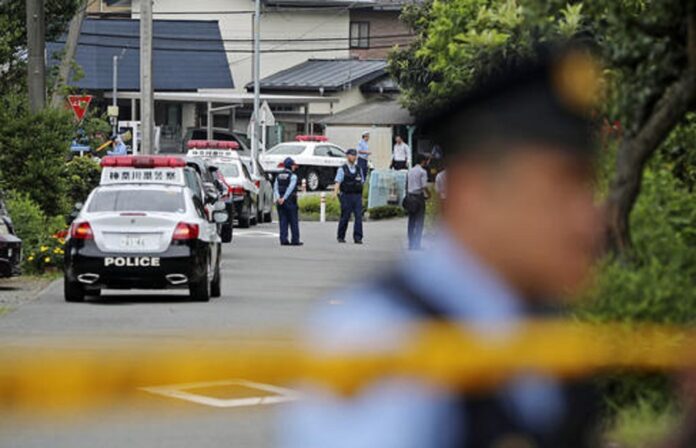 Police officers stand guard at a crossroad near the Tsukui Yamayuri-en, a facility for the handicapped, where a number of people were killed and dozens injured in a knife attack in Sagamihara, outside of Tokyo, Japan, Tuesday, July 26, 2016. Photo: Eugene Hoshiko