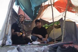 Azada Sayed, 23, left, and her husband, Hameed, 28, sit in their tent at a makeshift camp for migrants and refugees situated meters away from the Serbian border with Hungary, in Horgos, Serbia, Monday, July 4, 2016