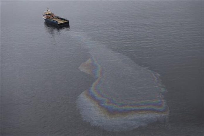 In this March 23, 2015 file photo, this aerial view shows a boat leaking oil in the waters of Guanabara Bay in Rio de Janeiro, Brazil. A new pollution problem has surfaced in Guanabara Bay, the venue for sailing in the Rio de Janeiro Olympics.