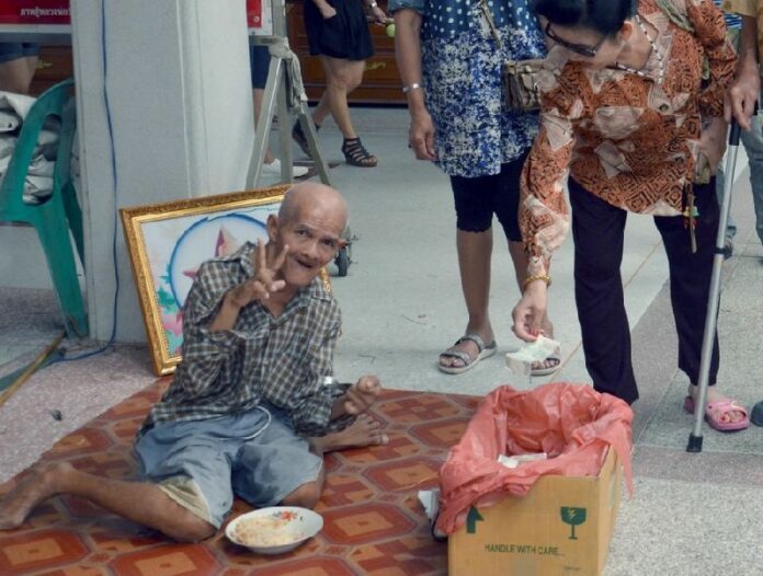 A beggar smiles outside Wat Rai Khing in Nakhon Pathom province in an undated photo. Photo: Matichon