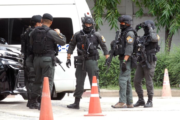 Commando police on Tuesday stand guard at Crime Suppression Division while the 11 suspects are brought to hear their charges.