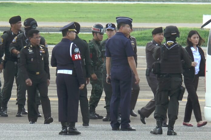 Former MP Tassanee Buranupakorn, at far right, is brought by police commandos and soldiers Tuesday to police headquarters in Chiang Mai province for questioning.
