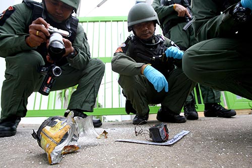 Security officers examine the fuse of bomb Saturday in Yala province.