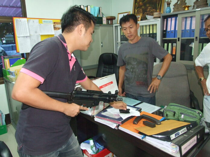 An officer checks the intercepted firearm on Thursday at Udon Thani City Police station.