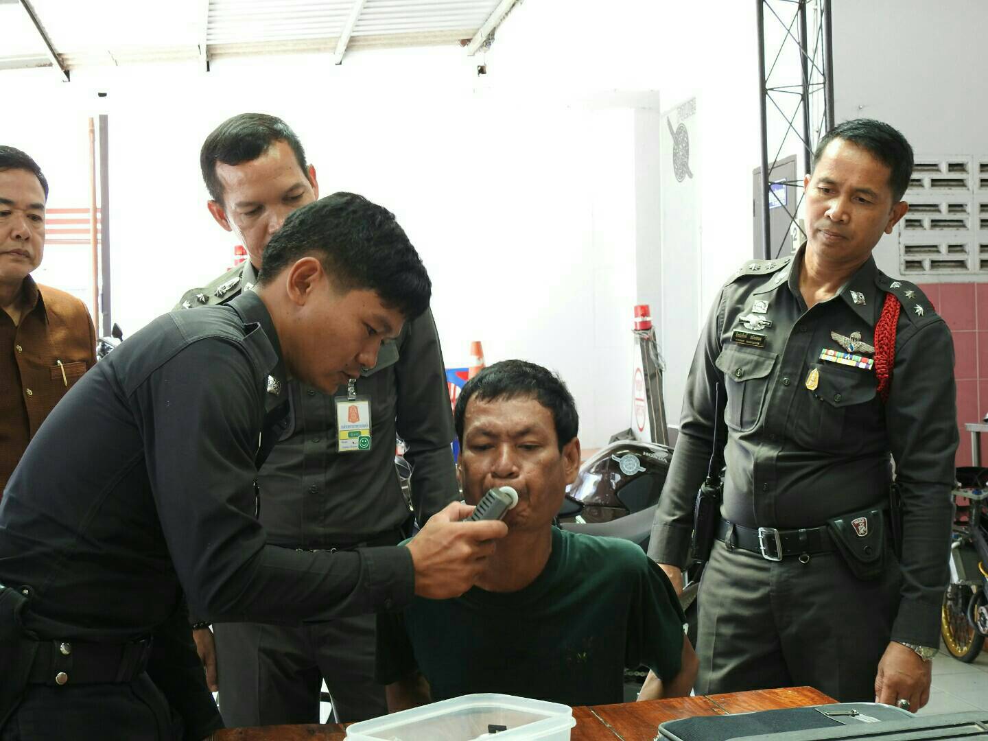 Sombat Boonsalee is given a breathalyzer test after being arrested for drunkenness at a Surin province polling station.