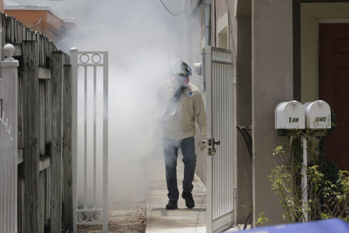 A Miami-Dade County mosquito control worker sprays around a home in the Wynwood area of Miami on Monday. Photo: Alan Diaz / Associated Press