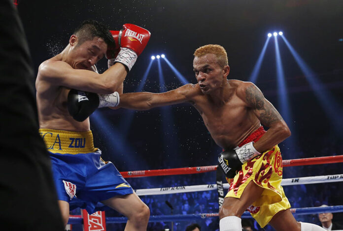 Amnat Ruenroeng, right, throws a punch at China's double Olympic gold medalist Zou Shiming during their IBF flyweight title boxing match on March 7, 2015, at the Venetian Macao in Macau. Photo: Kin Cheung / Associated Press
